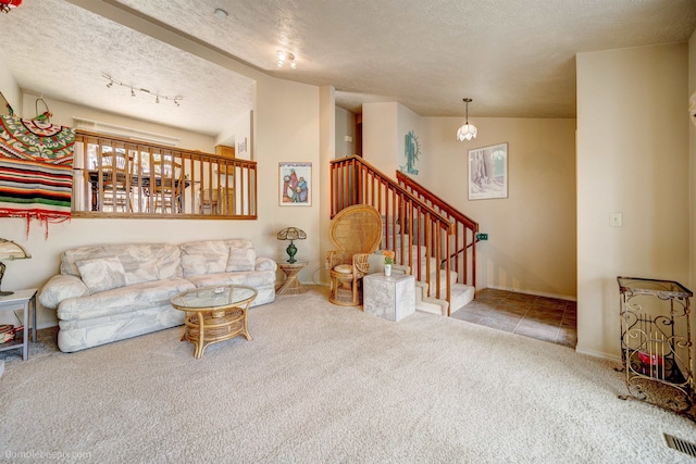 4112 E 11th Ave, Spokane, WA 99202 - carpeted living room with a textured ceiling, stairs, rail lighting, and baseboards