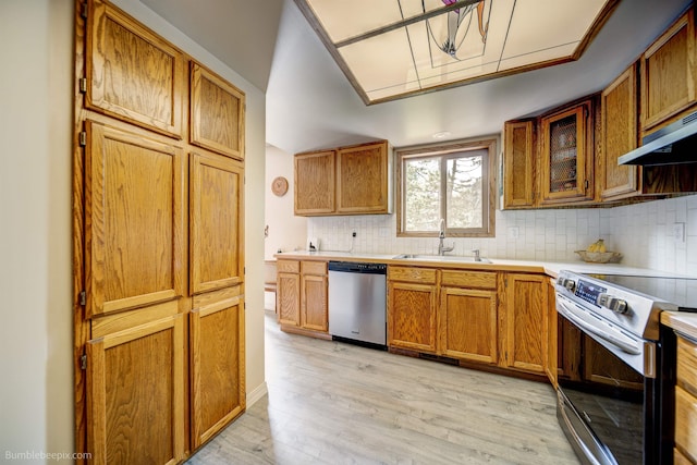 4112 E 11th Ave, Spokane, WA 99202 - kitchen featuring appliances with stainless steel finishes, a sink, light wood-type flooring, and backsplash