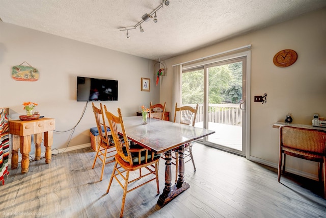 4112 E 11th Ave, Spokane, WA 99202 - dining space featuring a textured ceiling, wood finished floors, baseboards, and rail lighting