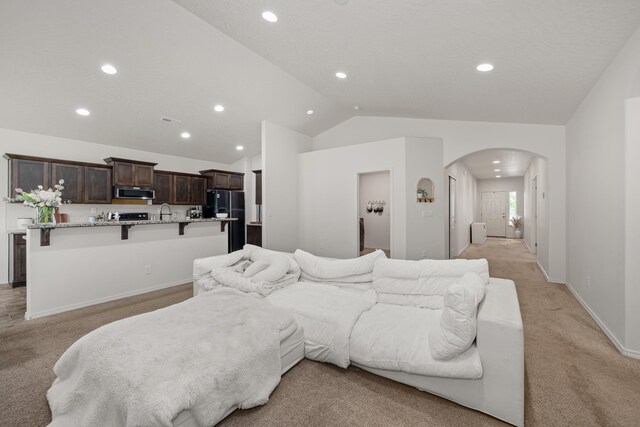 2026 W Parkway Ct, Spokane, WA 99208 - living area with arched walkways, light carpet, vaulted ceiling, recessed lighting, and baseboards