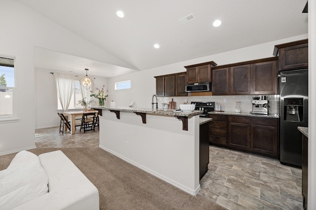 2026 W Parkway Ct, Spokane, WA 99208 - kitchen with appliances with stainless steel finishes, a kitchen breakfast bar, a center island with sink, dark brown cabinetry, and lofted ceiling