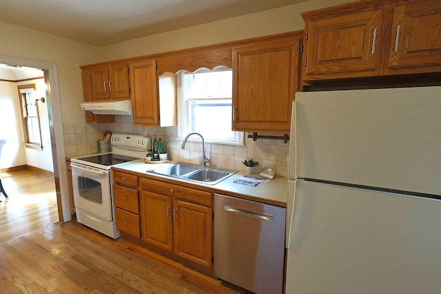 417 W 26th Ave, Spokane, WA 99203 - kitchen featuring white appliances, a sink, under cabinet range hood, light countertops, and light wood-style flooring