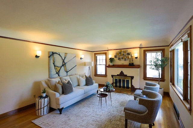 417 W 26th Ave, Spokane, WA 99203 - living room featuring wood finished floors, a brick fireplace, baseboards, and crown molding