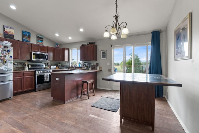 8710 N I Ct, Spokane, WA 99208 - kitchen featuring stainless steel appliances, a kitchen breakfast bar, light wood-style floors, a peninsula, and a chandelier