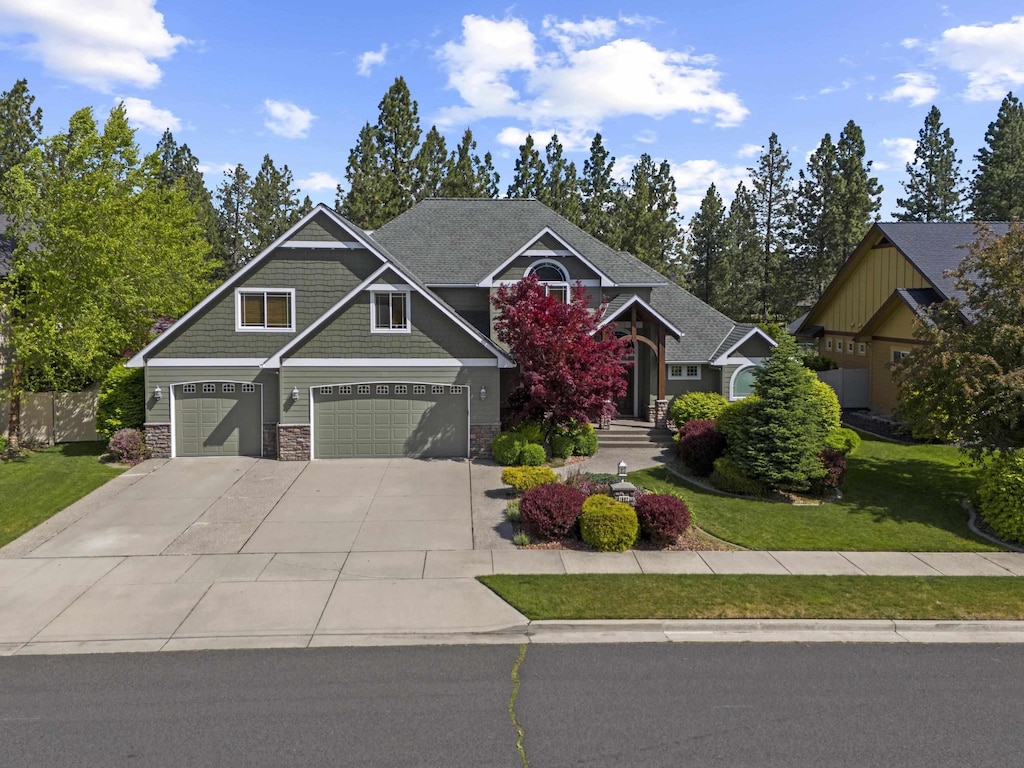 1602 W Panorama Ave, Spokane, WA 99208 - craftsman-style house featuring a garage, concrete driveway, a front lawn, and stone siding