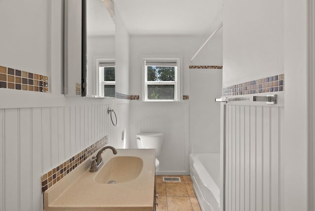 3215 W Longfellow Ave, Spokane, WA 99205 - bathroom featuring toilet, a wainscoted wall, shower / bathtub combination, vanity, and tile patterned floors