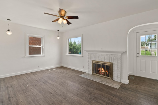3215 W Longfellow Ave, Spokane, WA 99205 - unfurnished living room featuring plenty of natural light, a ceiling fan, wood finished floors, and a fireplace