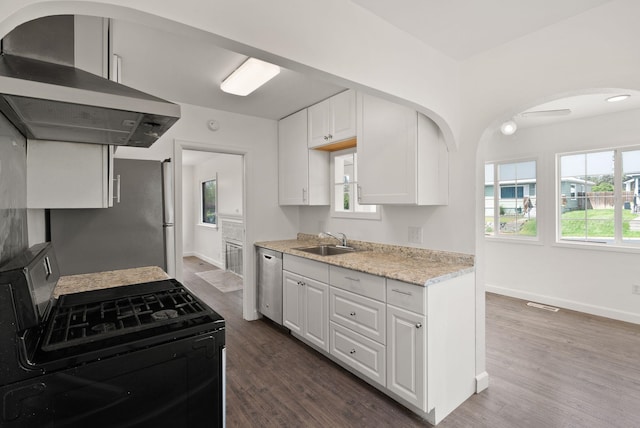 3215 W Longfellow Ave, Spokane, WA 99205 - kitchen featuring range hood, stainless steel appliances, a sink, arched walkways, and white cabinets