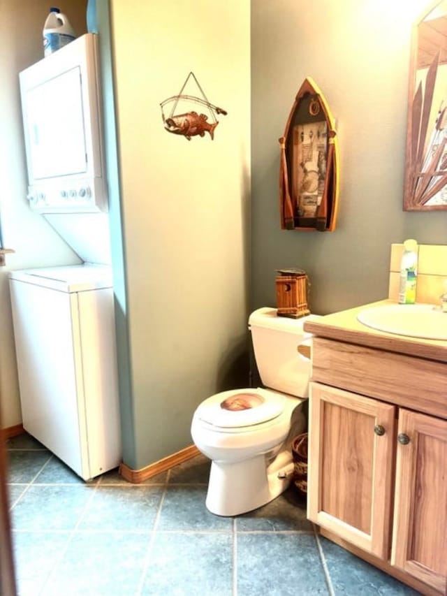 278 Hazel St, Cusick, WA 99119 - half bath featuring stacked washer / drying machine, vanity, toilet, and tile patterned flooring