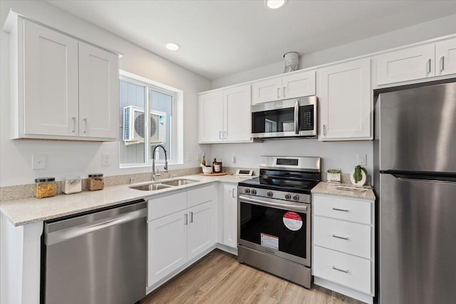 1912 W Buckeye Ave, Spokane, WA 99205 - kitchen with appliances with stainless steel finishes, a sink, white cabinets, light wood finished floors, and recessed lighting
