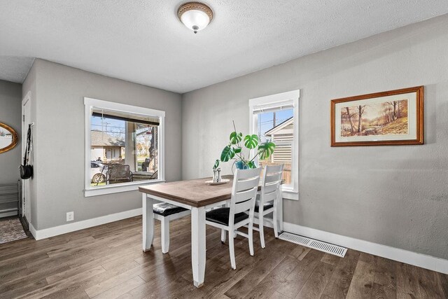 4824 N Stone St, Spokane, WA 99207 - dining room featuring wood finished floors, baseboards, plenty of natural light, and a textured ceiling