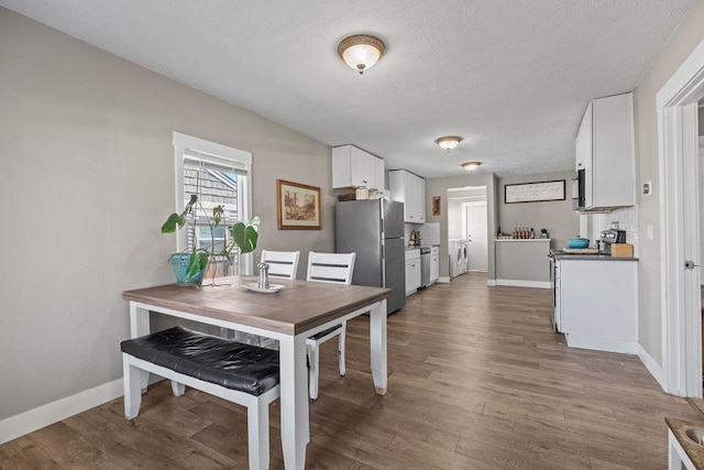 4824 N Stone St, Spokane, WA 99207 - dining space with baseboards, a textured ceiling, and wood finished floors