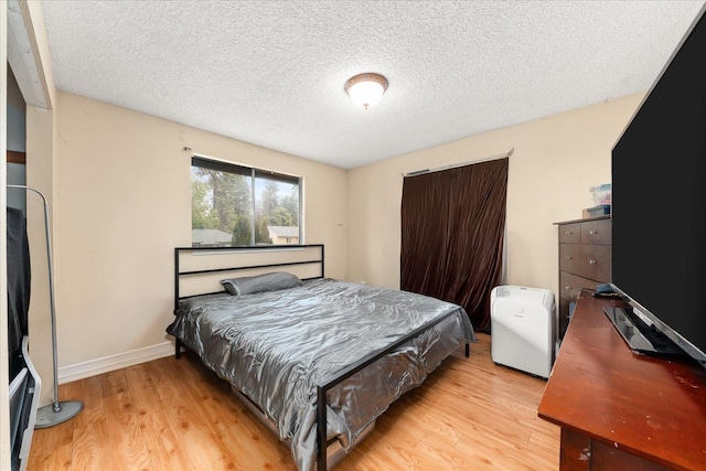 3712 E 12th Ave, Spokane, WA 99202 - bedroom featuring light wood finished floors, a textured ceiling, and baseboards