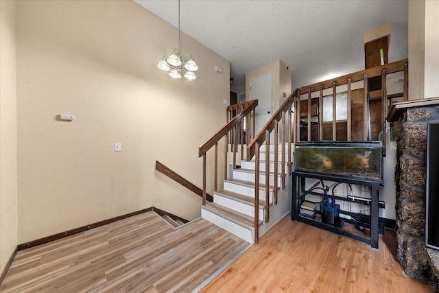 3712 E 12th Ave, Spokane, WA 99202 - stairway featuring wood finished floors, a chandelier, and baseboards