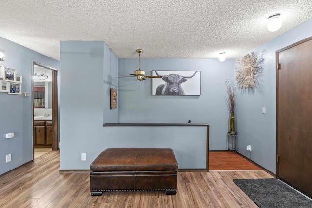 15906 N Forker Rd, Spokane, WA 99217 - living area featuring a textured ceiling, wood finished floors, ceiling fan, and baseboards