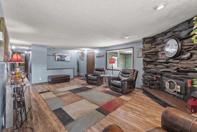 15906 N Forker Rd, Spokane, WA 99217 - living room featuring a textured ceiling, wood finished floors, and a fireplace