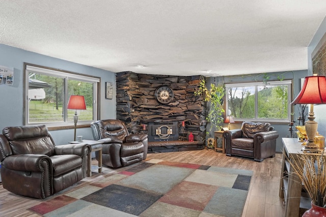 15906 N Forker Rd, Spokane, WA 99217 - living area featuring wood finished floors, a textured ceiling, and a stone fireplace