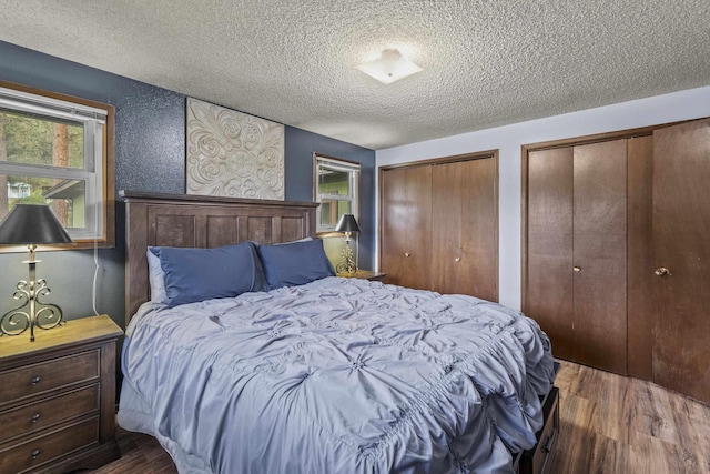 15906 N Forker Rd, Spokane, WA 99217 - bedroom featuring wood finished floors, a textured ceiling, and multiple closets