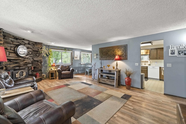 15906 N Forker Rd, Spokane, WA 99217 - living area featuring light wood-style flooring, a textured ceiling, and a fireplace
