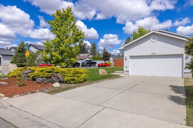 4701 E 13th Ave, Spokane Valley, WA 99212 - view of side of home featuring concrete driveway, an attached garage, a yard, and a residential view
