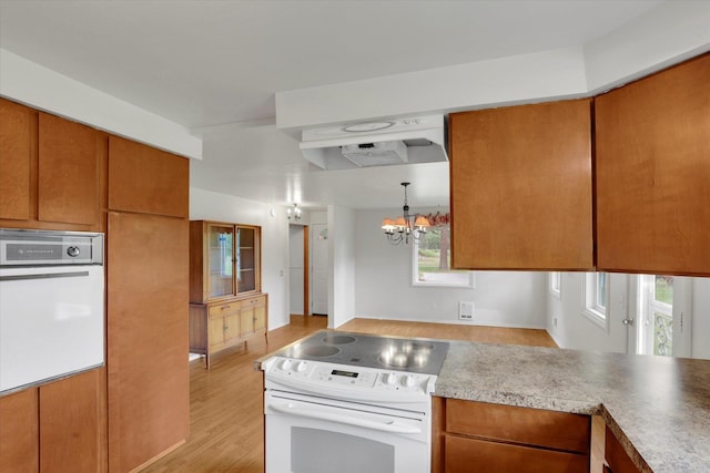 2111 W Mason Rd, Deer Park, WA 99006 - kitchen featuring white appliances, a chandelier, light wood-style flooring, and brown cabinetry
