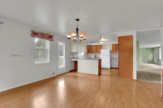 2111 W Mason Rd, Deer Park, WA 99006 - kitchen with freestanding refrigerator, open floor plan, a chandelier, and brown cabinetry