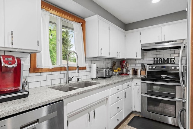 6721 N Washington St, Spokane, WA 99208 - kitchen with appliances with stainless steel finishes, under cabinet range hood, decorative backsplash, white cabinets, and recessed lighting