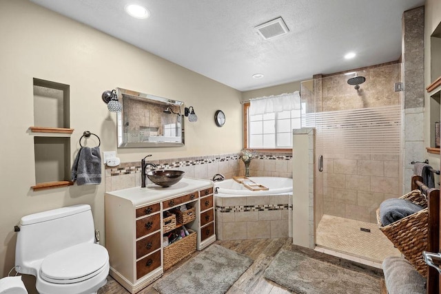 6721 N Washington St, Spokane, WA 99208 - full bath with a bath, a shower stall, vanity, wood finished floors, and recessed lighting