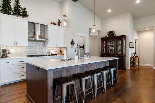 7203 S Tangle Heights Dr, Spokane, WA 99224 - kitchen with wall chimney exhaust hood, black gas stovetop, tasteful backsplash, dark wood-type flooring, and high vaulted ceiling