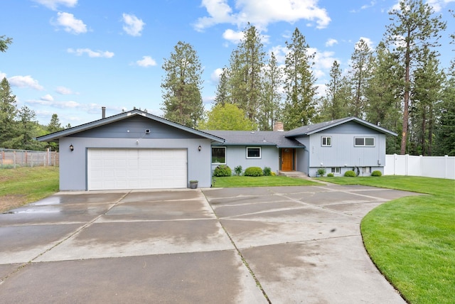9815 E 44th Ave, Spokane Valley, WA 99206 - split level home featuring an attached garage, driveway, and a chimney