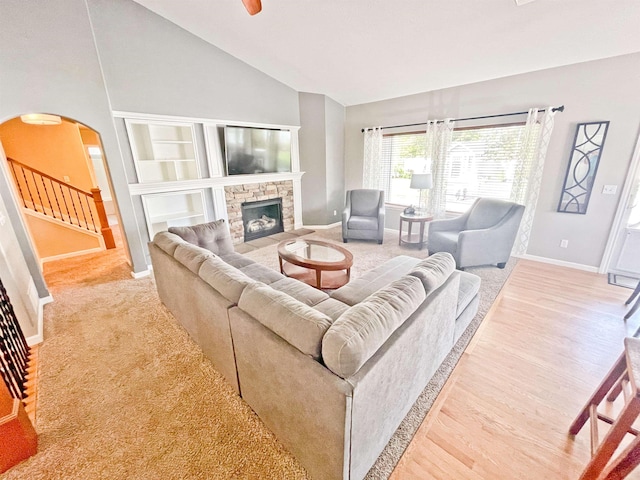1602 S Canyon Woods Ln, Spokane, WA 99224 - living room with baseboards, arched walkways, a stone fireplace, light wood finished floors, and high vaulted ceiling
