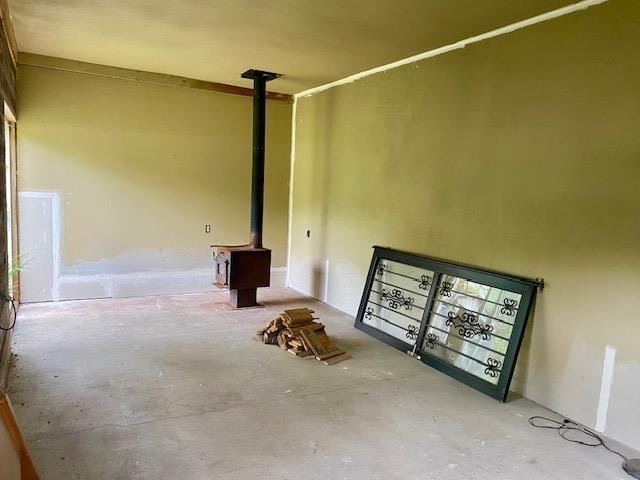4410 Williams Valley Rd, Clayton, WA 99110 - spare room featuring unfinished concrete flooring and a wood stove