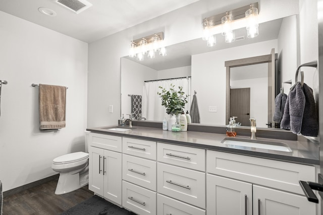 1116 Greenfield Dr, Cheney, WA 99004 - full bathroom featuring wood finished floors, double vanity, toilet, and baseboards