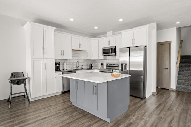 1116 Greenfield Dr, Cheney, WA 99004 - kitchen with stainless steel appliances, a center island, dark wood finished floors, a sink, and white cabinets