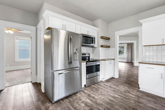 2305 W Sharp Ave, Spokane, WA 99201 - kitchen with appliances with stainless steel finishes, dark wood-type flooring, decorative backsplash, and white cabinetry