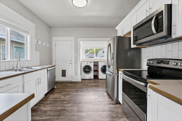 2305 W Sharp Ave, Spokane, WA 99201 - kitchen featuring appliances with stainless steel finishes, washer and dryer, a sink, backsplash, and white cabinetry