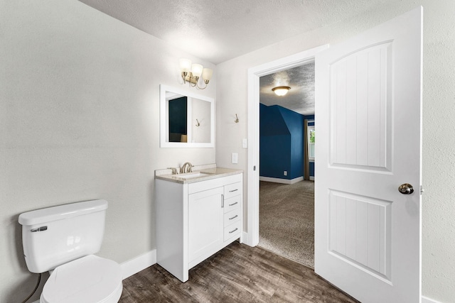 2305 W Sharp Ave, Spokane, WA 99201 - half bathroom featuring vanity, toilet, a textured ceiling, wood finished floors, and baseboards