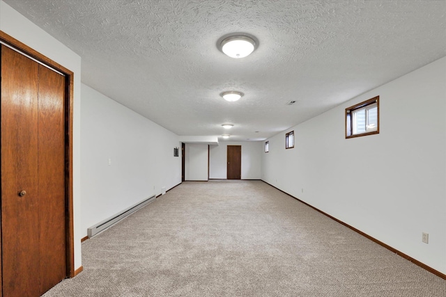 4921 W Londale Ct, Spokane, WA 99208 - empty room with a baseboard heating unit, light carpet, a textured ceiling, and baseboards