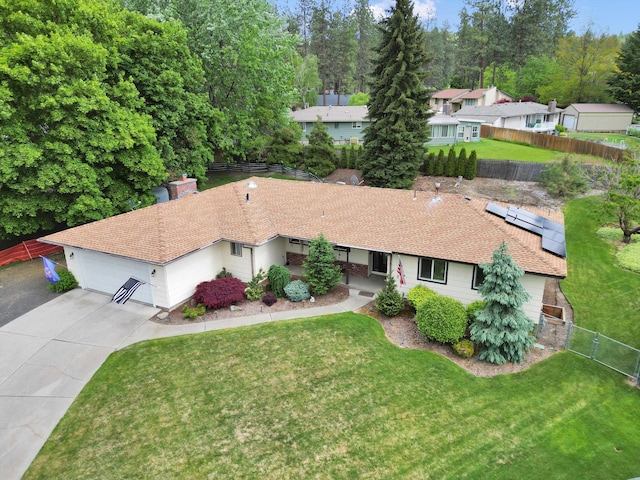 4921 W Londale Ct, Spokane, WA 99208 - view of front facade featuring driveway, an attached garage, roof mounted solar panels, a chimney, and a shingled roof