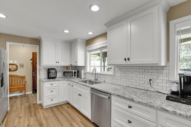 4921 W Londale Ct, Spokane, WA 99208 - kitchen with stainless steel appliances, a sink, white cabinetry, decorative backsplash, and light wood-style flooring