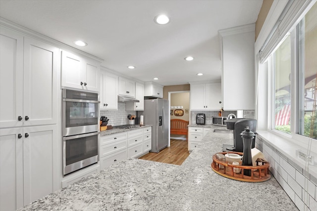 4921 W Londale Ct, Spokane, WA 99208 - kitchen with stainless steel appliances, under cabinet range hood, backsplash, white cabinets, and recessed lighting