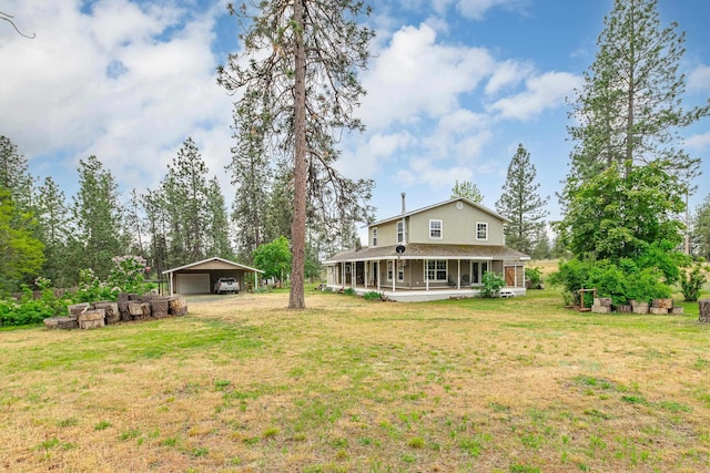 6325 W 48th Ave, Spokane, WA 99224 - rear view of house featuring an outbuilding, a yard, covered porch, a carport, and a shingled roof