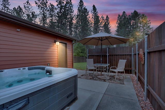 15711 N Unicorn Ct, Mead, WA 99021 - patio terrace at dusk featuring a hot tub, a patio area, outdoor dining area, and a fenced backyard