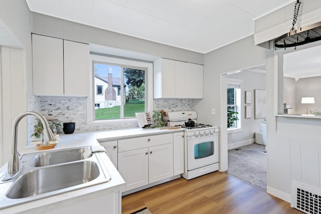 2526 E 8th Ave, Spokane, WA 99202 - kitchen with white gas range, a sink, white cabinets, and light countertops