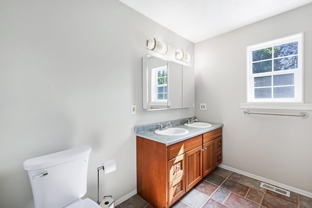 2526 E 8th Ave, Spokane, WA 99202 - bathroom featuring baseboards, toilet, plenty of natural light, and double vanity