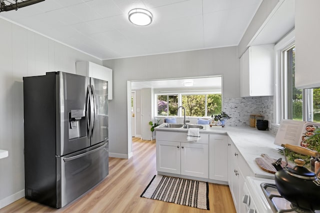 2526 E 8th Ave, Spokane, WA 99202 - kitchen featuring stainless steel refrigerator with ice dispenser, a sink, light wood-style floors, white cabinetry, and crown molding