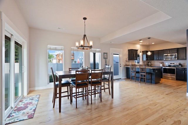 18218 E Michielli Ave, Spokane Valley, WA 99016 - dining room featuring light wood finished floors, a chandelier, and baseboards