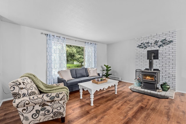 122 E Circle Dr, Newport, WA 99156 - living area featuring wood finished floors, a wood stove, baseboards, and a baseboard heating unit