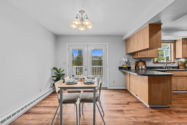 122 E Circle Dr, Newport, WA 99156 - dining space featuring baseboard heating, a chandelier, light wood-style floors, and baseboards
