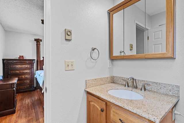 122 E Circle Dr, Newport, WA 99156 - bathroom with vanity, hardwood / wood-style flooring, ensuite bath, a textured ceiling, and a textured wall